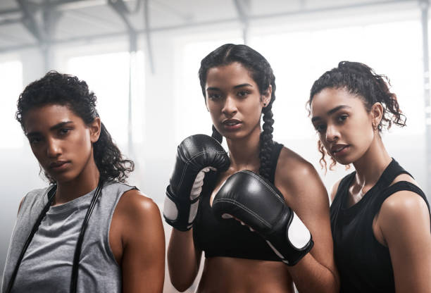 portrait of a group of fit young women boxing together at the gym