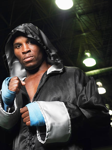 boxer wearing robe with hood up, clenching fists, portrait