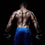 rear view of muscular black male wearing boxing gloves